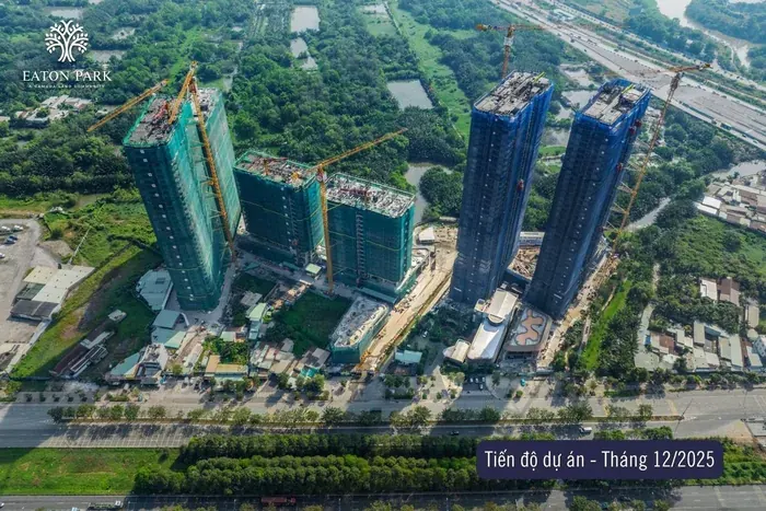 Ảnh chụp tiến độ Eaton Park từ trên cao, tháng 12 năm 2025. Các tòa tháp đang vươn lên dưới lưới bao che, hồ bơi khối đế và cảnh quan đang thi công.